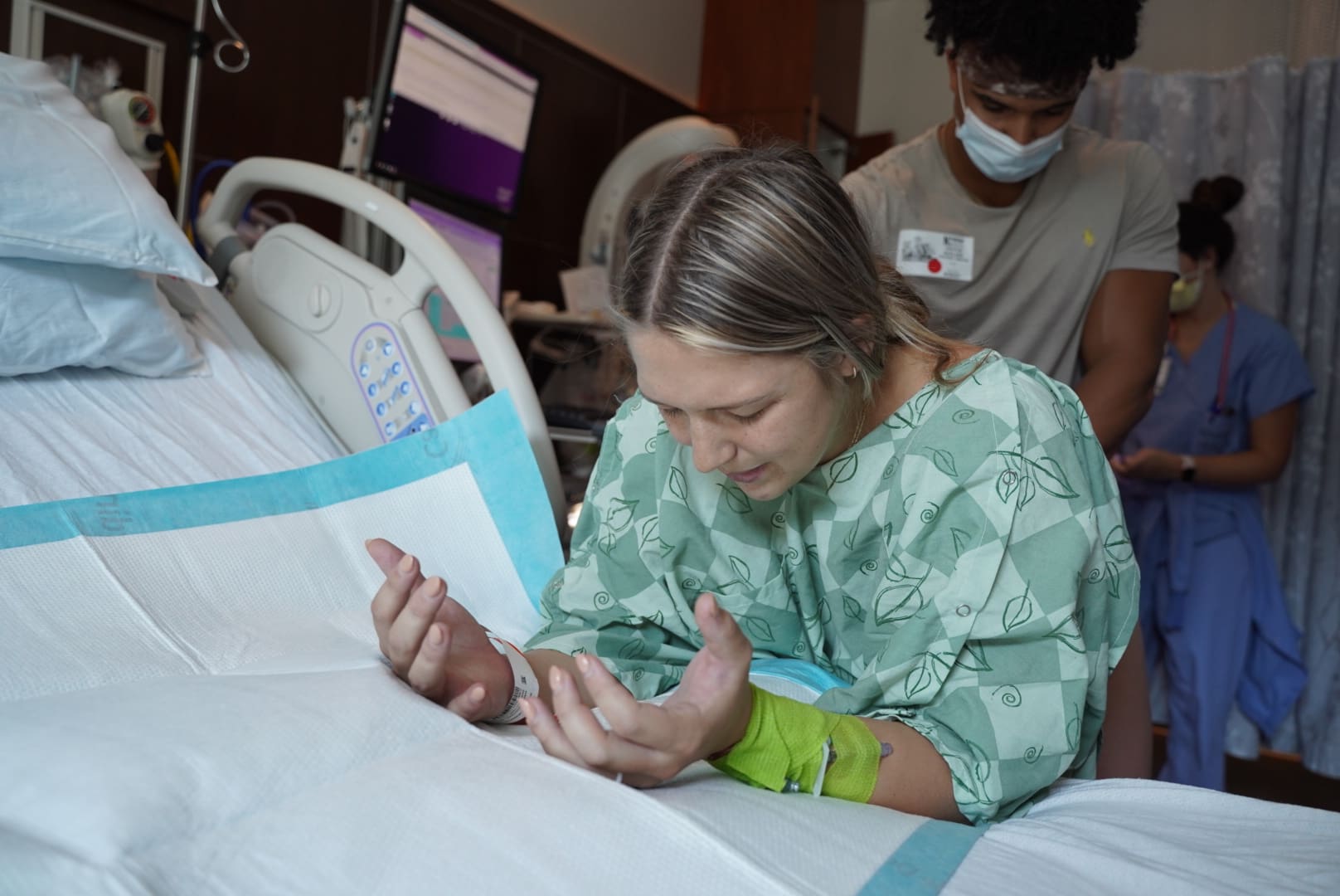 Charlotte NC birth doula providing hands-on support to a laboring mother preparing for an unmedicated hospital birth.